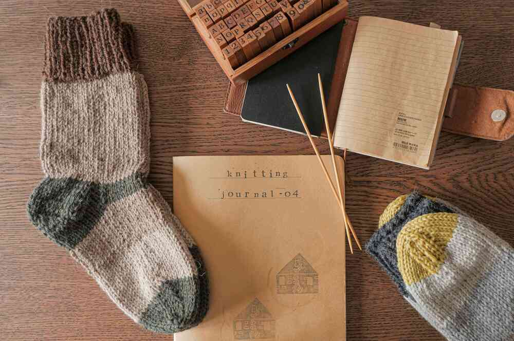 Wool socks on a table with a knitting journal